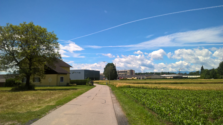 Plain under blue sky, with blocky featureless factory buildings