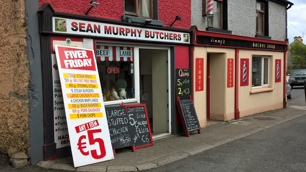 Sean Murphy's butcher's shop with a board advertising Fiver Friday, next to Jimmy’s Barber Shop